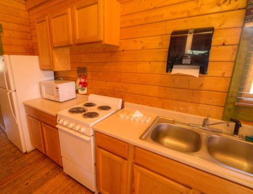 a kitchen with a white stove top oven next to a sink at Medina Highpoint RV Resort in Medina