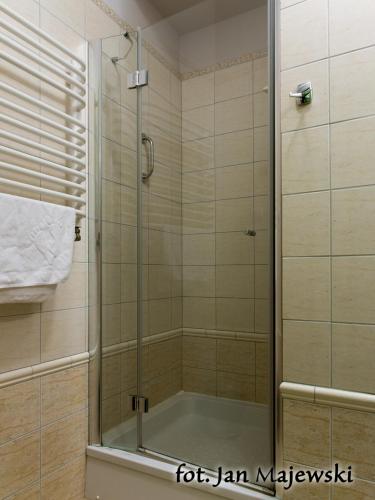 a shower with a glass door in a bathroom at Majewski Hotel & SPA in Malbork