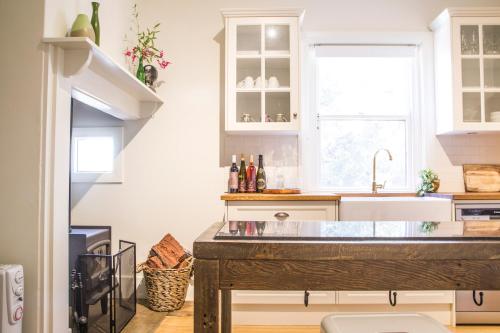 a kitchen with white cabinets and a sink at Mataro Cottage in Tanunda