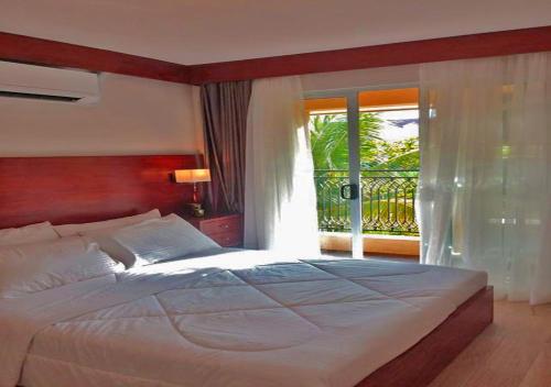 um quarto com uma cama grande e uma janela em Pacheco Oasis em Cebu