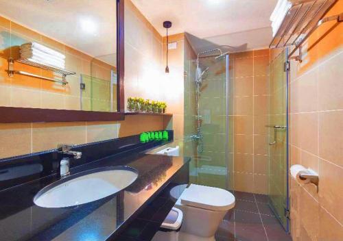 ein Bad mit einem Waschbecken, einem WC und einer Glasdusche in der Unterkunft Pacheco Oasis in Cebu City