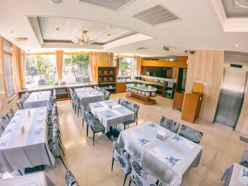 a dining room with white tables and chairs at Foung Jia Hotel in Magong