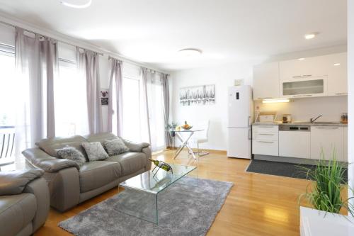a living room with a couch and a kitchen at Apartment Rio in Podstrana