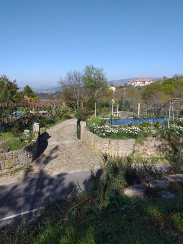 a path leading to a garden with a pool at Cabana da Oliveira in Marco de Canaveses