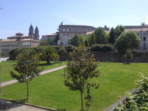 un parque verde con árboles y edificios al fondo en Hostal Pumar, en Santiago de Compostela