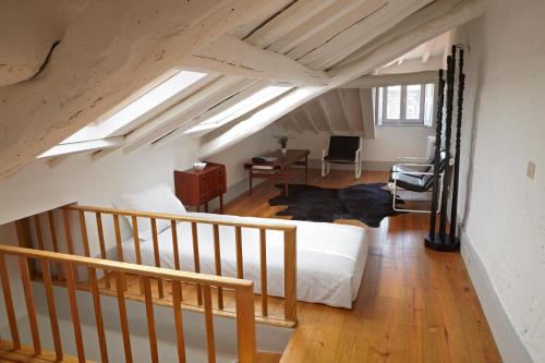 a attic room with a bed and a staircase at Pensao Favorita in Porto