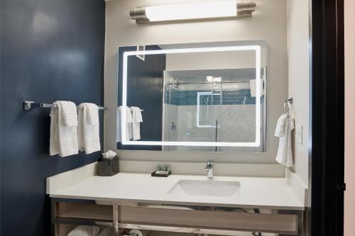 a bathroom with a sink and a large mirror at Grand Hilton Head Inn, Ascend Hotel Collection in Hilton Head Island