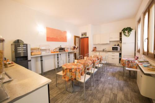 a kitchen with a row of tables and chairs at Bed & Breakfast Camollia in Siena