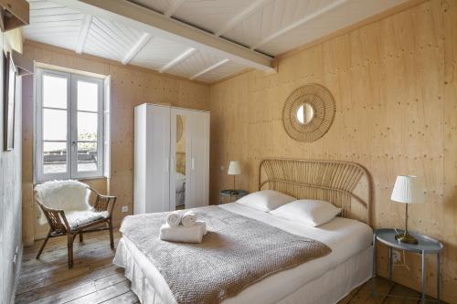 une chambre avec un grand lit et une chaise dans l'établissement La Hune by Cocoonr, à Saint-Malo