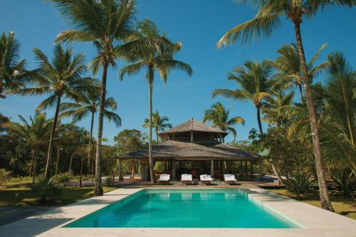 - une piscine avec des palmiers et un kiosque dans l'établissement Hotel Vila Naià - Corumbau, à Corumbau