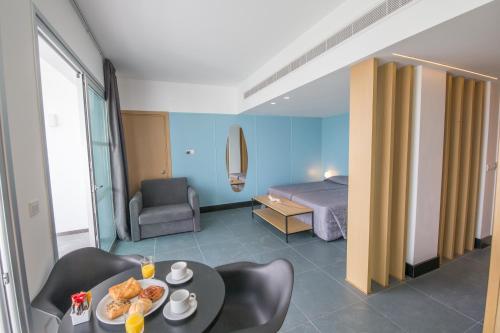 a hotel room with a bed and a table with food on it at Anthea Hotel Apartments in Ayia Napa