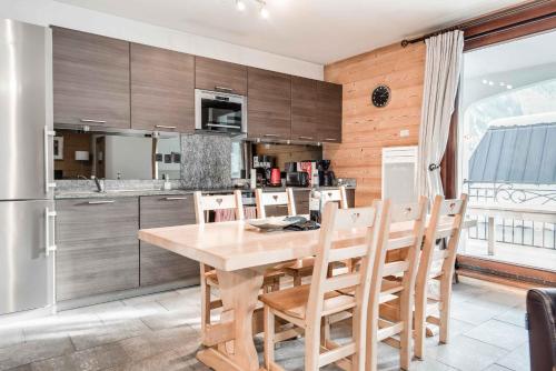 une cuisine avec une table et des chaises en bois dans l'établissement Le Paradis 27 apartment - Chamonix All Year, à Chamonix-Mont-Blanc