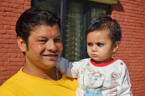 a man holding a young child in front of a building at Planet Bhaktapur Hotel in Bhaktapur