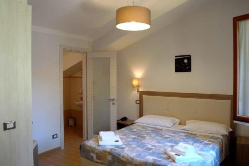 a bedroom with a bed with two towels on it at Antiche Terre Hotel & Relax in Pignone