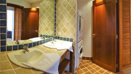 a bathroom with a sink and a large mirror at A ALTEZZA Palombaggia in Porto-Vecchio