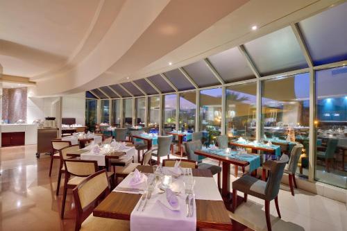 a restaurant with tables and chairs and windows at Majestic City Retreat Hotel in Dubai