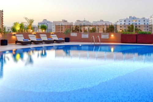 a large swimming pool on the roof of a building at Majestic City Retreat Hotel in Dubai