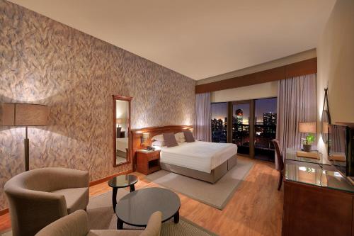a hotel room with a bed and a living room at Majestic City Retreat Hotel in Dubai
