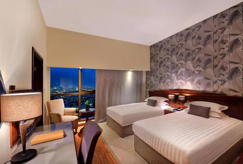 a hotel room with two beds and a window at Majestic City Retreat Hotel in Dubai