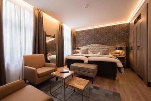 a hotel room with a bed and a chair at Hotel Acacia in Bruges