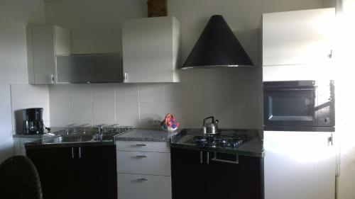 a kitchen with a sink and a stove top oven at Gite Bleu in MÃ©nil-Vin