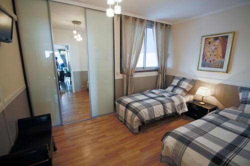 Cette chambre comprend 2 lits et un miroir. dans l'établissement Sea view luxury apartment, à Saint-Laurent-du-Var