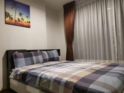 4 Floor - Centrio Condominium in Phuket town في فوكيت تاون: غرفة نوم مع سرير وبطانية منقوشة