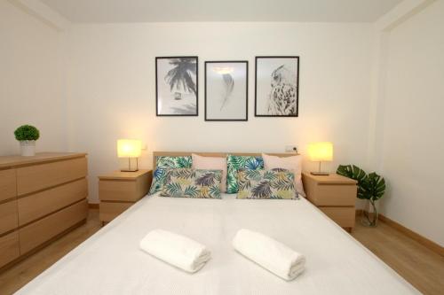 ガンディアにあるApartamento Eivissa 800 m de la Playa de Gandíaのベッドルーム(白い大型ベッド、ランプ2つ付)