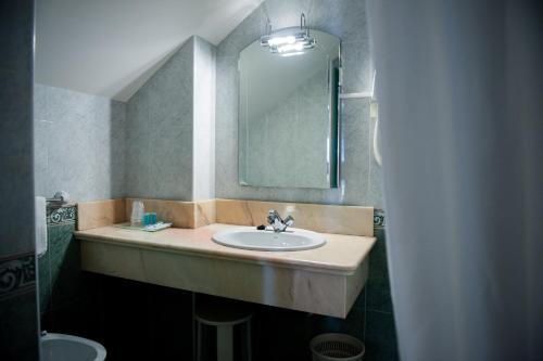a bathroom with a sink and a mirror at Hotel las Dunas in Noja