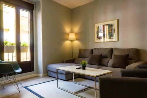 a living room with a couch and a table at Arenal Suites Puerta del Sol in Madrid