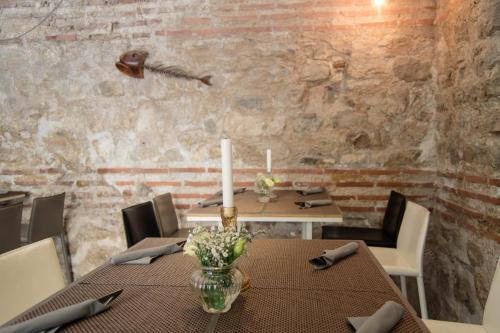 a dining room with a table and a brick wall at Heritage Hotel Cardo in Split