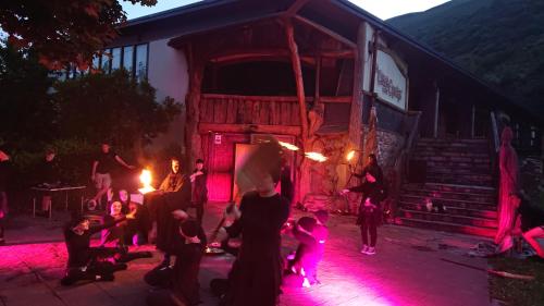 a group of people standing outside of a building with pink lights at Casa Rural Pandelo in Vega de Valcarce