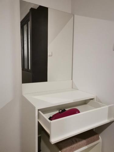 a white bathroom with a mirror and a red object at 4 Floor - Centrio Condominium in Phuket town in Phuket