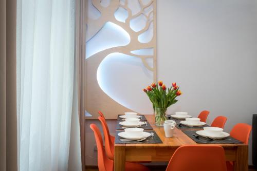 stół jadalny z krzesłami i wazon kwiatów w obiekcie Oasis by Cozyplace w Krakowie