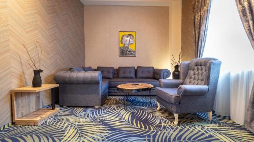 a living room with a couch and two chairs at ART Hotel in Sibiu