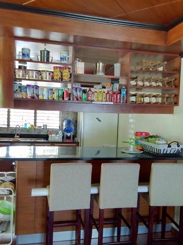a kitchen with a bar with chairs in it at Ancelle Cristo Re in Moalboal