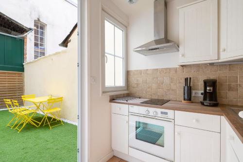 une cuisine avec des placards blancs et un sol vert dans l'établissement BLUE LAGOON by Cocoonr, à Rennes