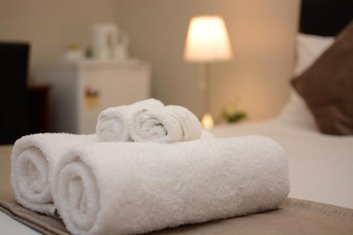 een stapel handdoeken bovenop een bed bij Ellard Bed & Breakfast in Perth