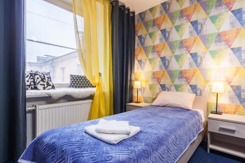a bedroom with a bed and a colorful wall at Ligovsky yard in Saint Petersburg