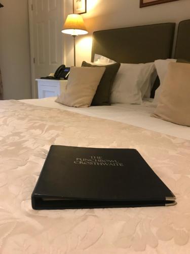 a black laptop sitting on top of a bed at The Punch Bowl Inn in Kendal