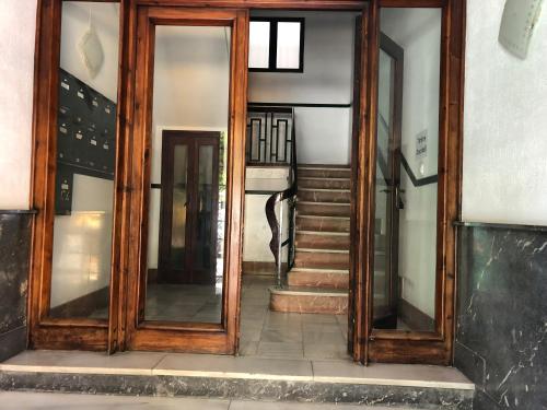 a hallway with two large wooden doors and stairs at Lodgingmalaga Cristo de la Epidemia in Málaga