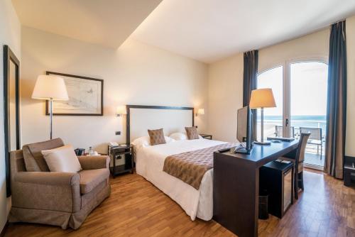 a hotel room with a bed and a desk and a chair at Terrazza Marconi Hotel&Spamarine in Senigallia