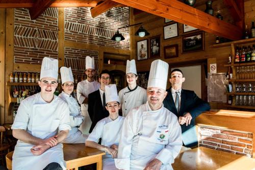 un grupo de chefs posando para una foto en una cocina en Logis Hôtel Le Tilia, en Joux