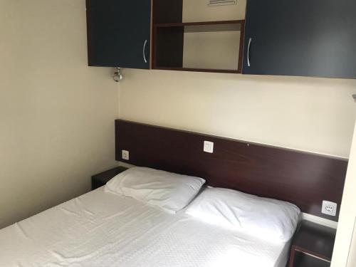 a bed with a wooden headboard and a mirror above it at Villaggio Costa d'Argento in San Vito Chietino