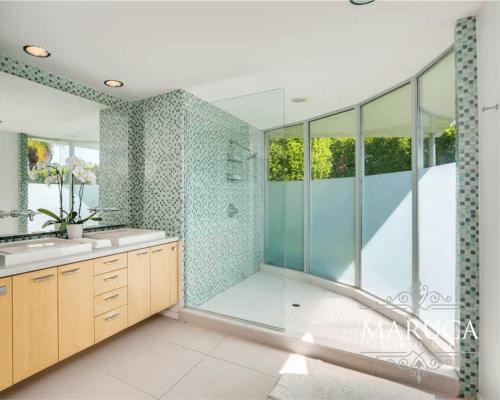 a bathroom with a walk in shower and a sink and a shower at Villa Finola in Palm Springs