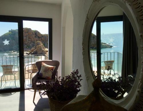 a mirror in a room with a chair and a balcony at Hostal Sa Malica in Blanes