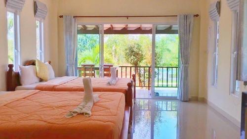 a bedroom with two beds and a balcony with a view at KP Mountain Beach in Pran Buri