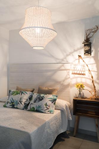a bedroom with a bed with a lamp and a table at Hostal Sa Malica in Blanes