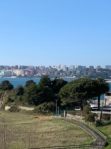 a park with a fence and a tree on a hill at hotel la trainera in Pedreña