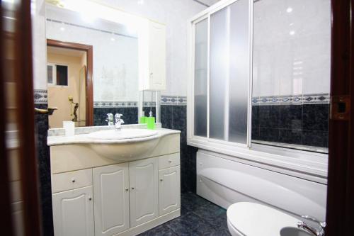 baño con lavabo y aseo y ventana en Apartamento SERAFÍN de la Caleta en Cádiz